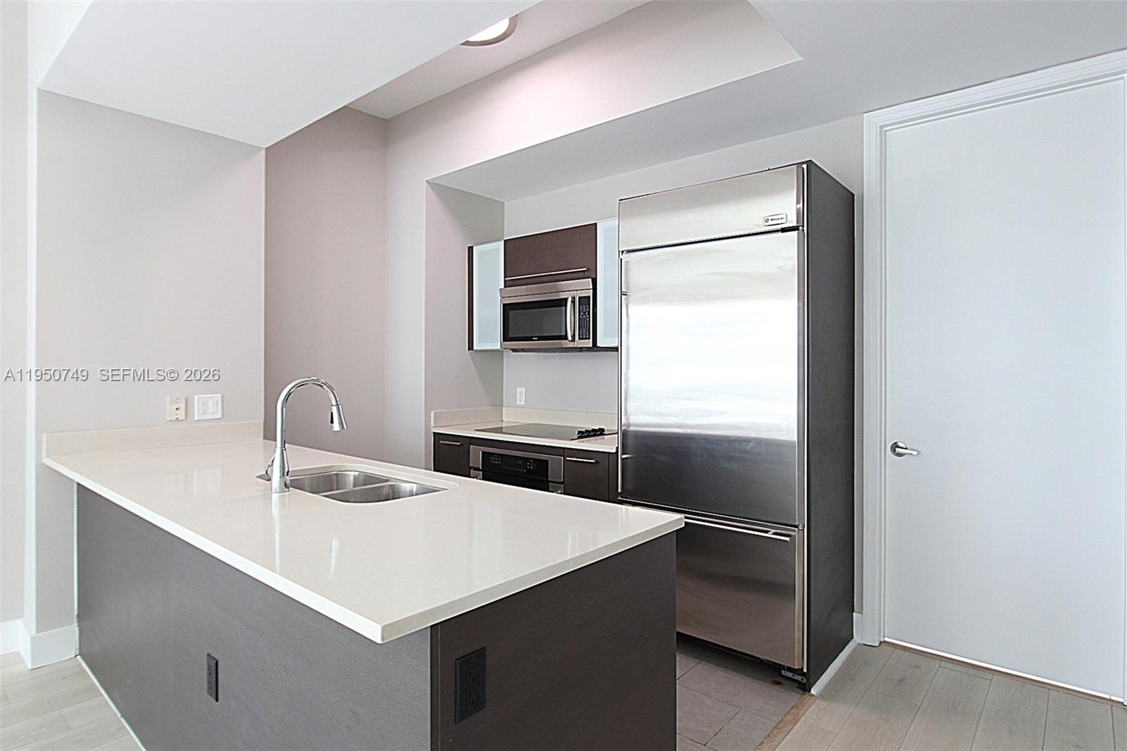 500 Brickell Avenue, Unit 4110 Miami, FL 33131 - Photo 7 of 34 a kitchen with a sink a refrigerator and a stove