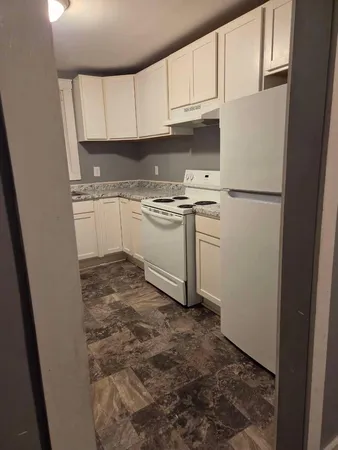 a kitchen with a refrigerator sink and cabinets