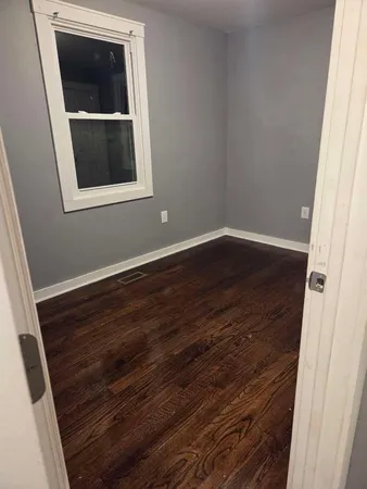 a view of a small space with wooden floor and a door