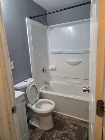a bathroom with a toilet and a shower