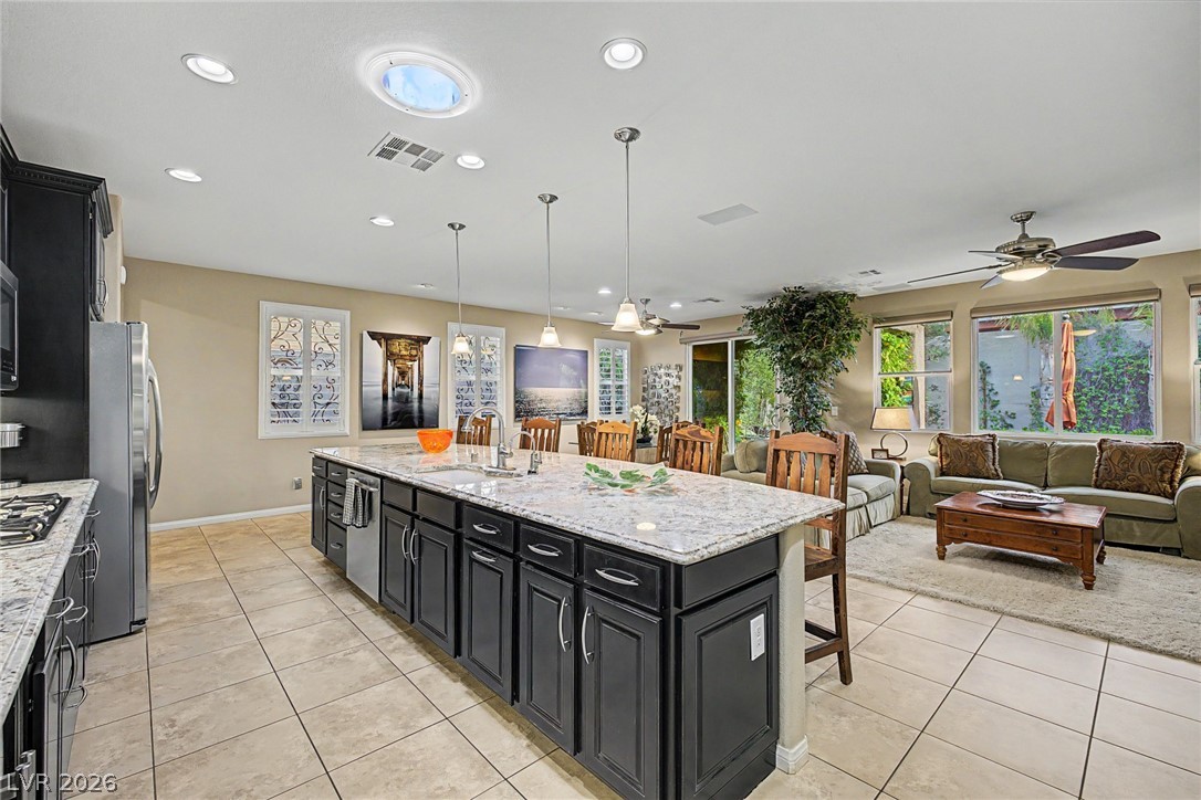 7415 Campbell Ranch Avenue Las Vegas, NV 89179 - Photo 3 of 52 An open-concept living area boasts a generously sized kitchen island with granite counters, seamlessly connecting to a luminous living space.