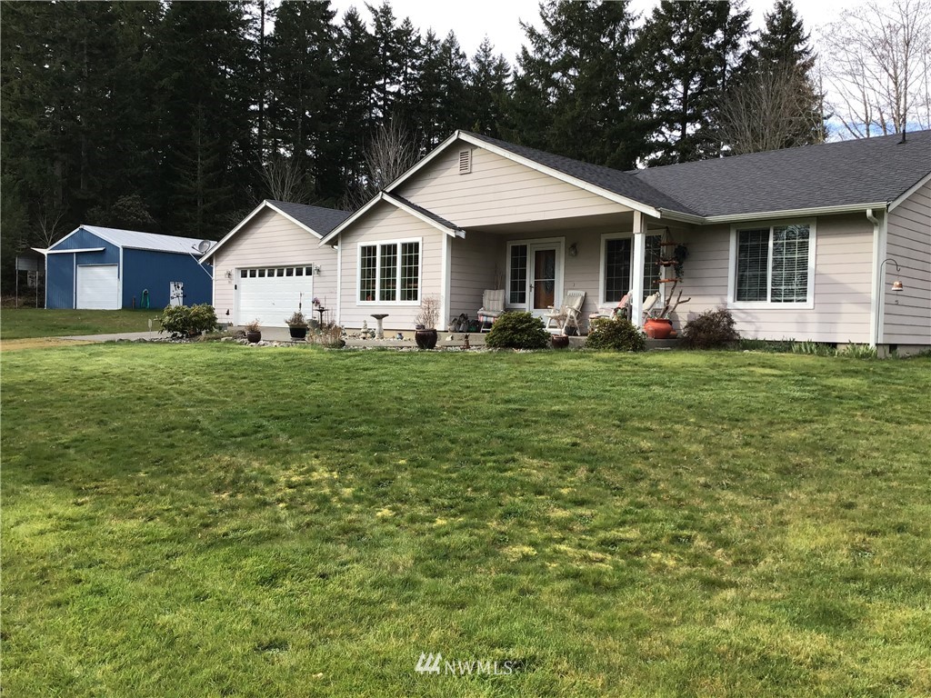 761 East Victor Road Belfair, WA 98528 - Photo 3 of 33 a front view of a house with a garden and porch