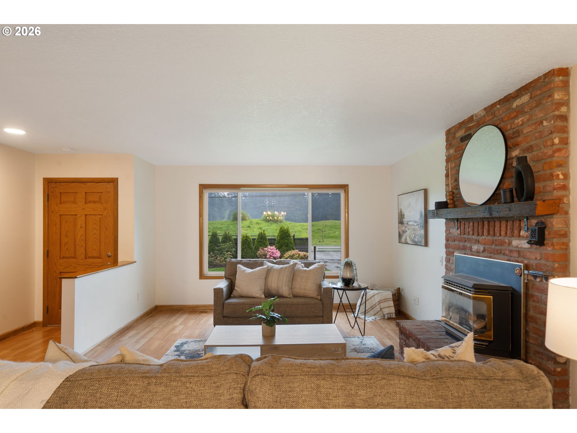 24950 Airport Road Northeast Aurora, OR 97002 - Photo 6 of 44 a living room with furniture a fireplace and a large window