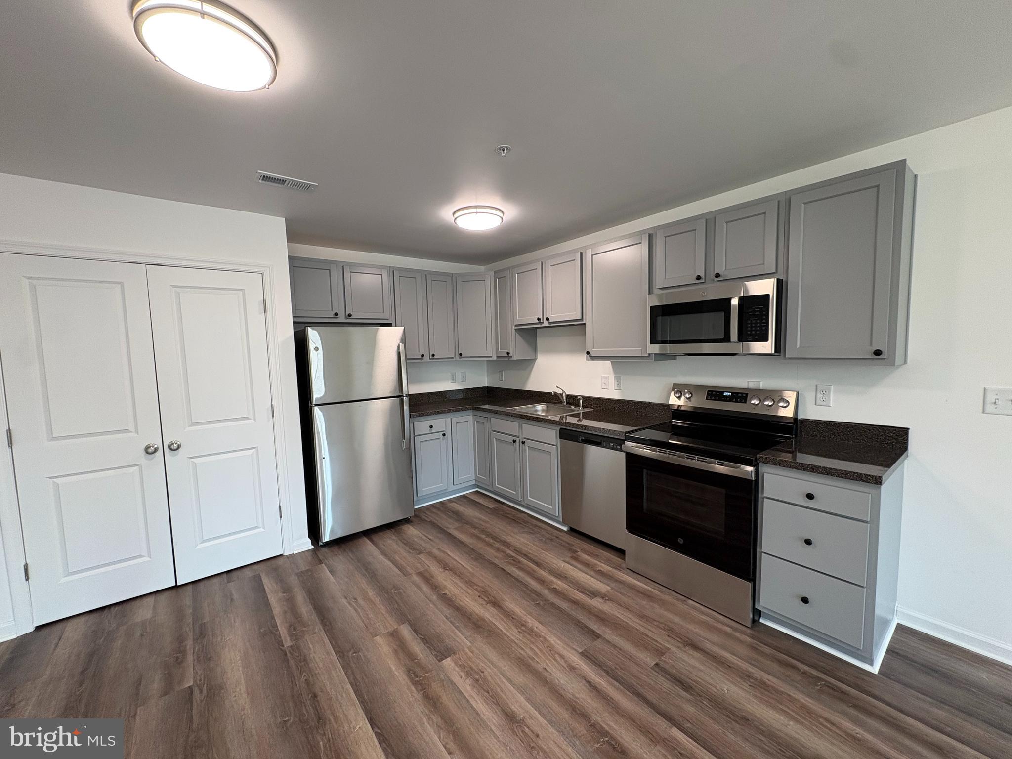 106 West All Saints Street, Unit B2 Frederick, MD 21701 - Photo 8 of 16 a kitchen with granite countertop a refrigerator stove top oven and sink