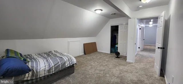 an empty room with closet and a chandelier fan