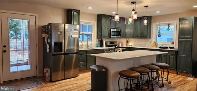 a kitchen with a sink a refrigerator and chairs
