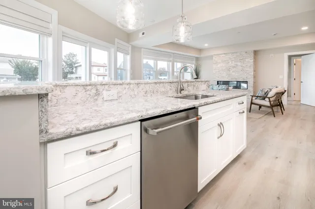a kitchen with granite countertop a sink a window and chairs