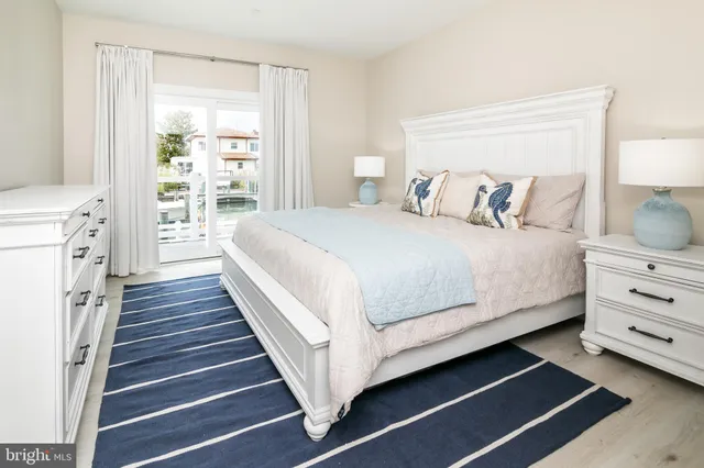 a large bed sitting in a bedroom next to a window with a dresser