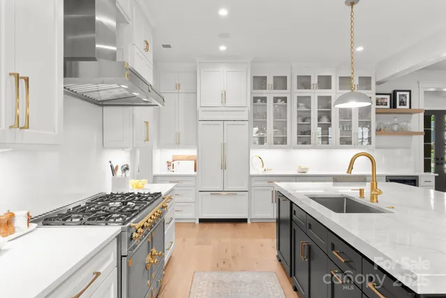 a kitchen with stainless steel appliances granite countertop a sink stove and refrigerator