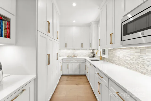 a kitchen with white cabinets sink and stainless steel appliances