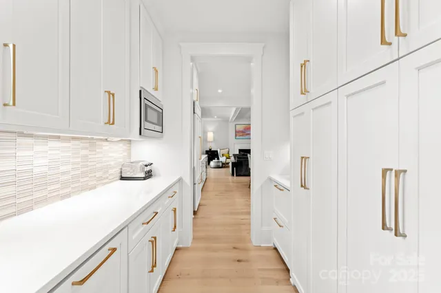 a kitchen with white cabinets and sink