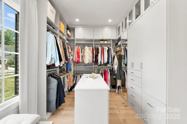 a view of walk in closet with clothes and shoes