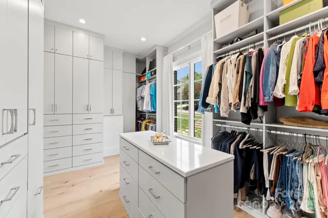 a view of walk in closet with clothes and shoes