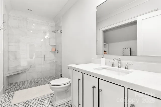 a bathroom with a sink a toilet and shower