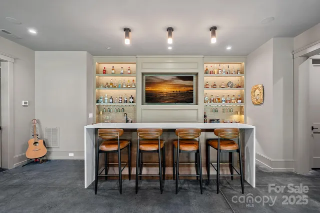 a kitchen with stainless steel appliances a dining table chairs and couches