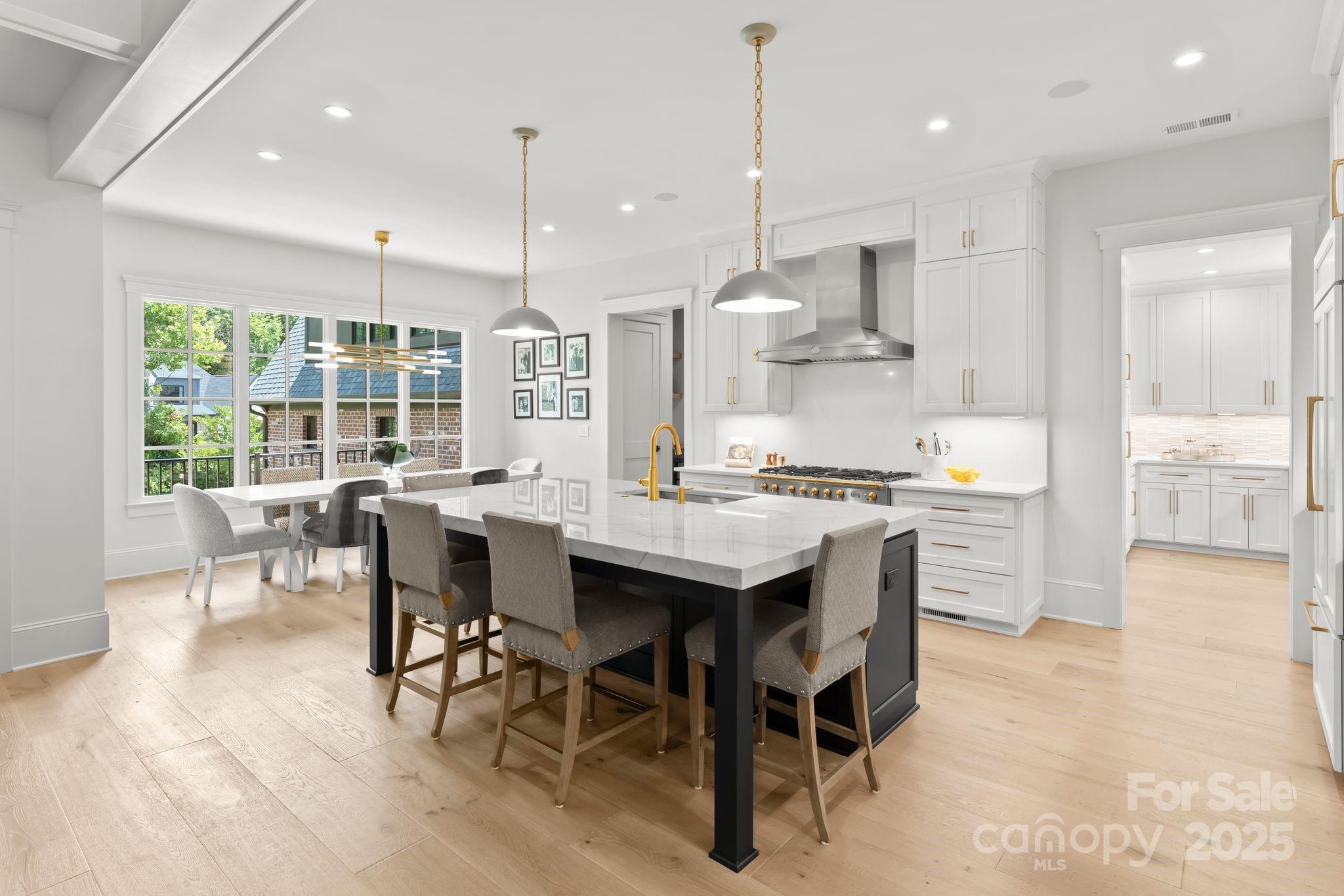 21216 Olde Quarry Lane Cornelius, NC 28031 - Photo 8 of 48 a kitchen with stainless steel appliances granite countertop a stove a refrigerator a kitchen island a table and chairs