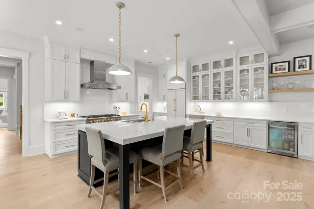 a kitchen with kitchen island a stove a table and chairs in it