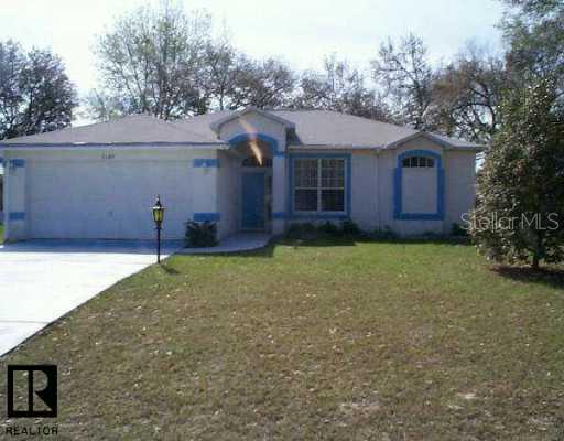 9386 Hayward Road Spring Hill, FL 34608 - Photo 1 of 1 a front view of a house with a yard and garage