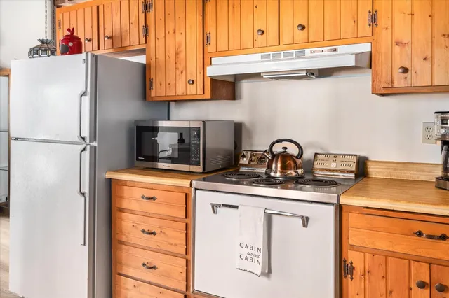a kitchen with appliances a sink and cabinets