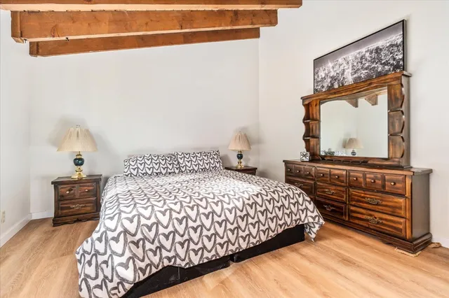 a bedroom with a bed and dresser with mirror