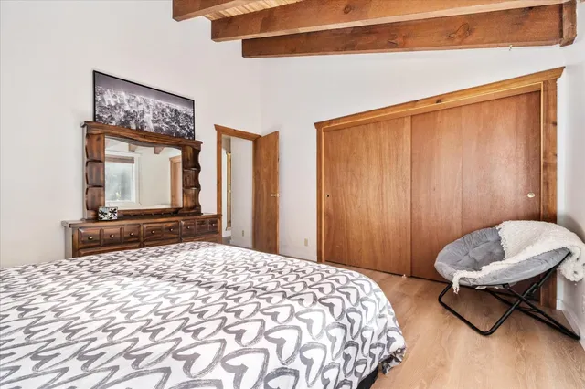 a bedroom with a bed a mirror and a table in it