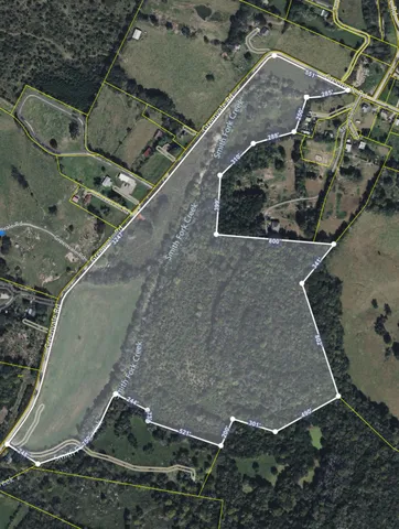 a view of a green field with wooden fence