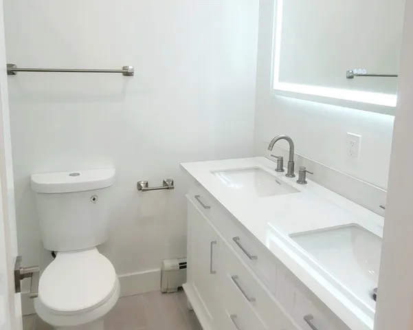 a bathroom with a sink mirror vanity and toilet