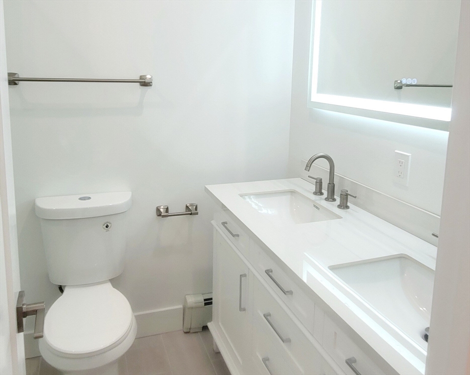 53 West Eagle Street, Unit 2 Boston, MA 02128 - Photo 4 of 7 a bathroom with a sink mirror vanity and toilet
