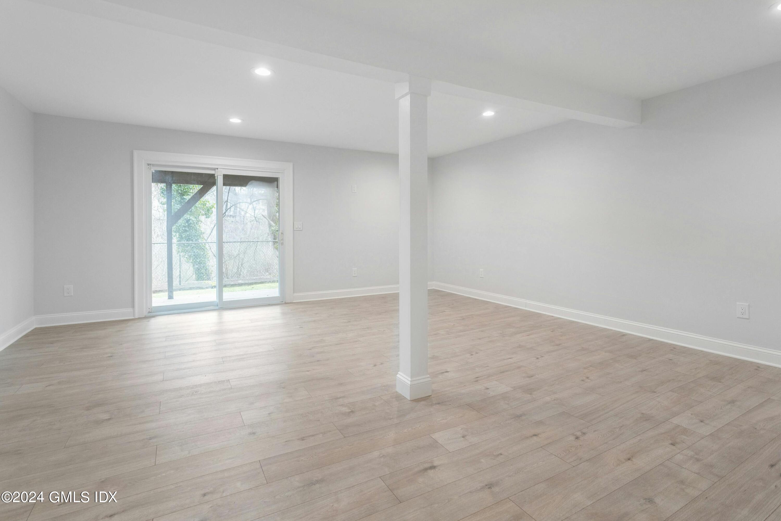 37 Sheep Hill Road, Unit 12 Riverside, CT 06878 - Photo 15 of 23 an empty room with wooden floor and windows