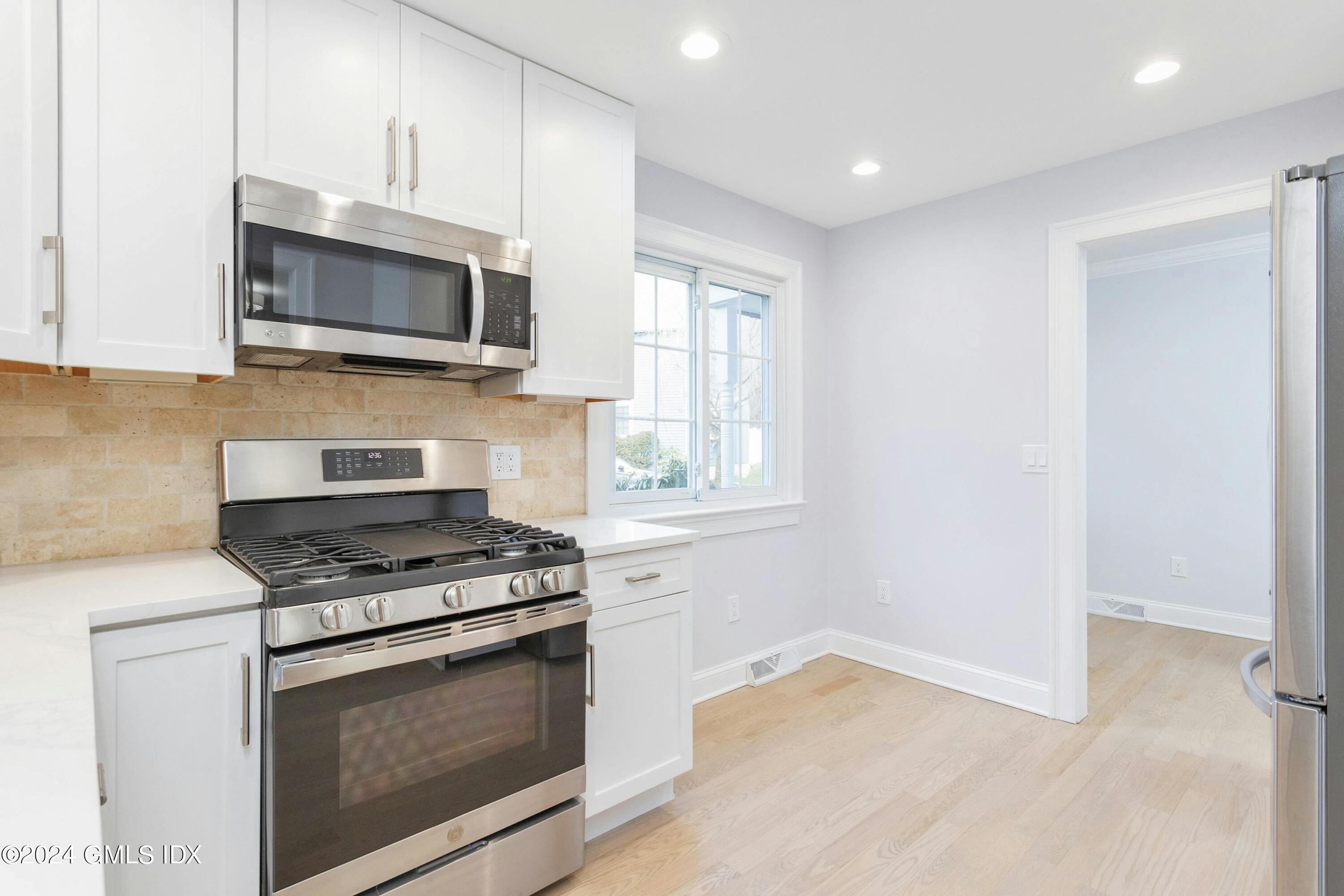 37 Sheep Hill Road, Unit 12 Riverside, CT 06878 - Photo 7 of 23 a kitchen with white cabinets and appliances