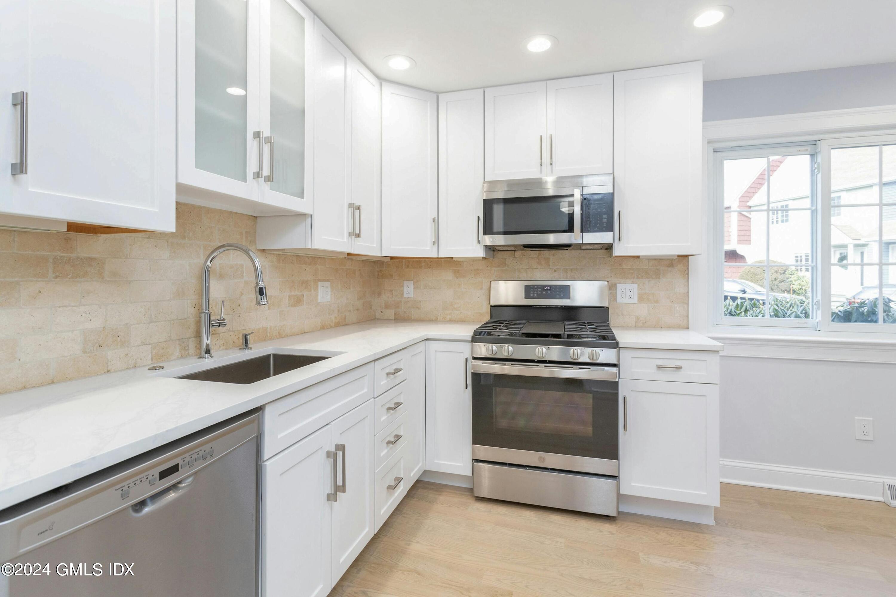 37 Sheep Hill Road, Unit 12 Riverside, CT 06878 - Photo 8 of 23 a kitchen with granite countertop white cabinets and stainless steel appliances