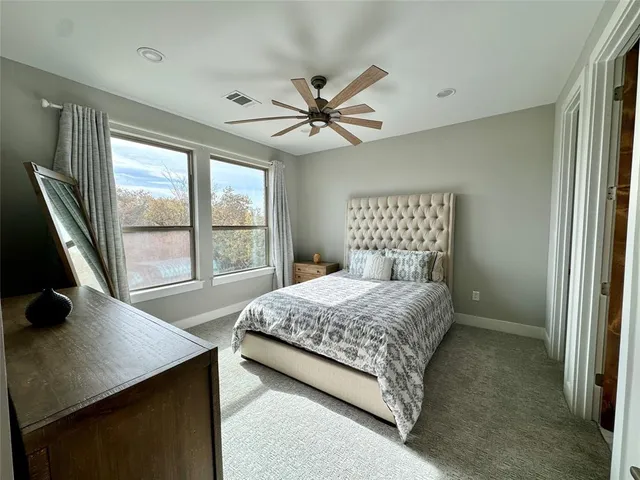 a bedroom with a bed and a large window