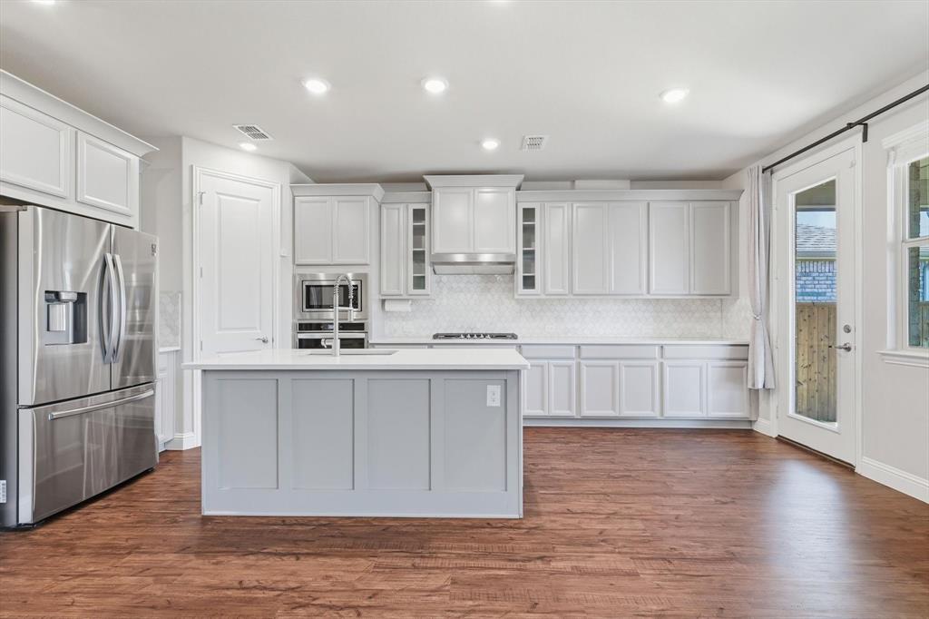 4125 Caprock Canyon Road Sachse, TX 75048 - Photo 11 of 40 a kitchen with stainless steel appliances granite countertop a refrigerator sink and white cabinets