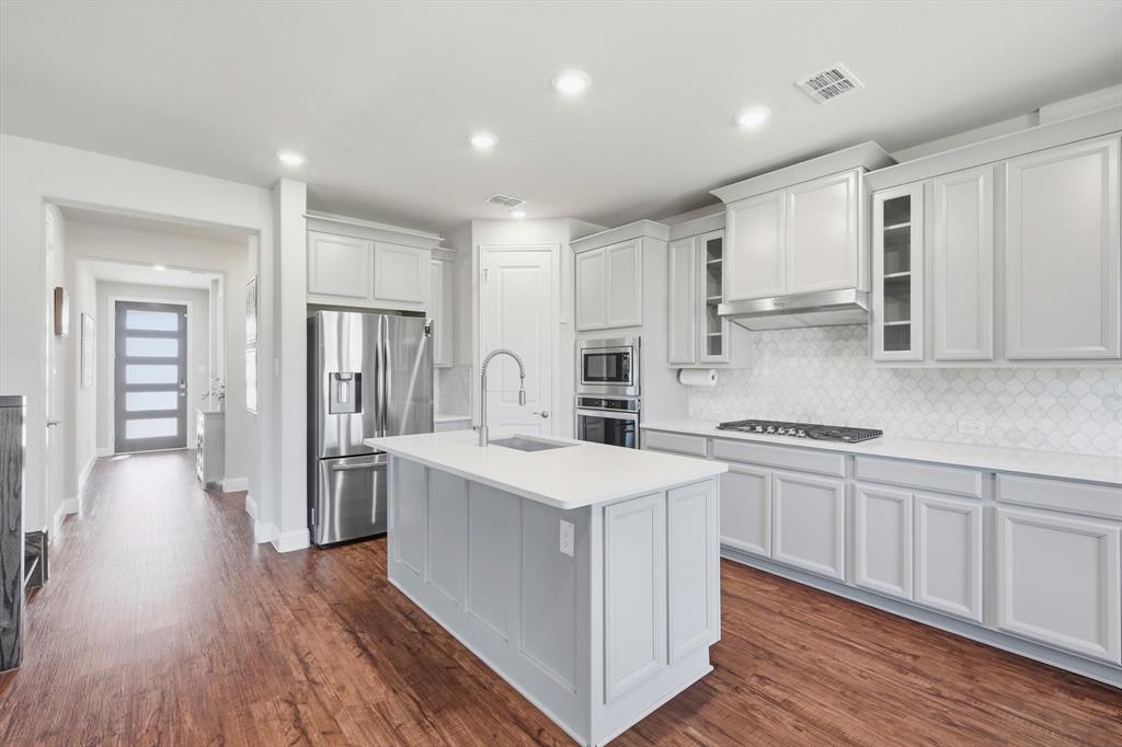 4125 Caprock Canyon Road Sachse, TX 75048 - Photo 12 of 40 a kitchen with stainless steel appliances granite countertop a sink stove and refrigerator