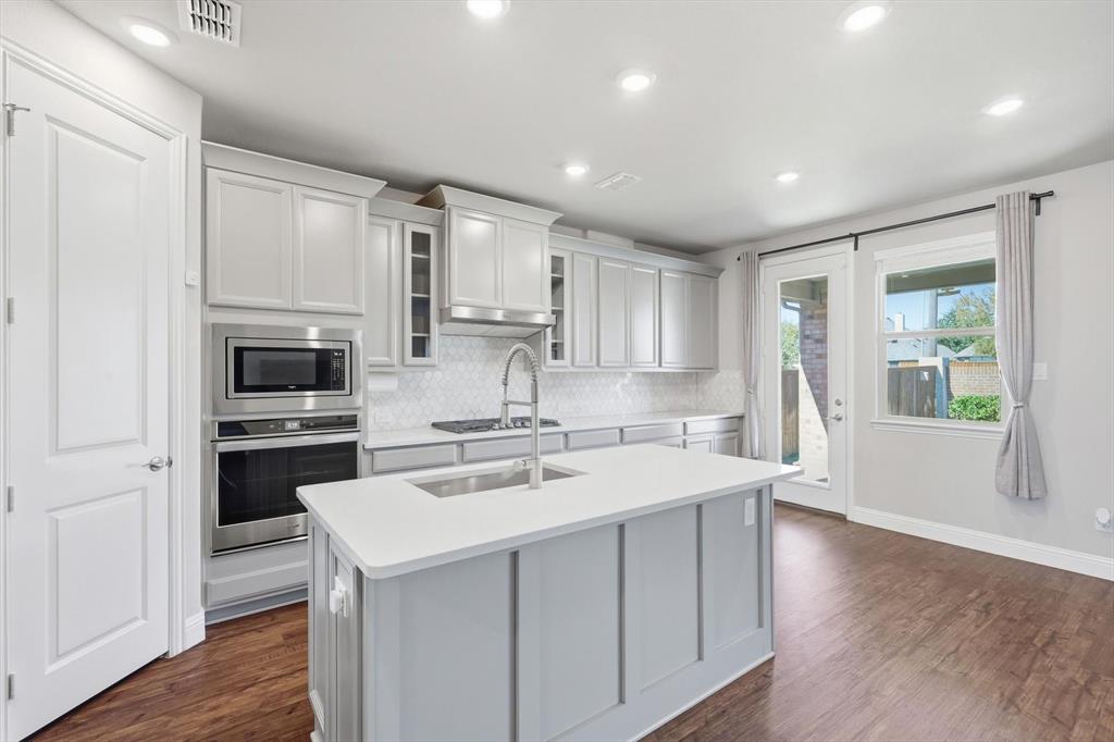 4125 Caprock Canyon Road Sachse, TX 75048 - Photo 13 of 40 a kitchen with stainless steel appliances a stove sink microwave and cabinets