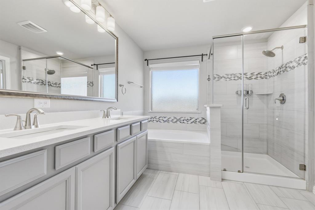 4125 Caprock Canyon Road Sachse, TX 75048 - Photo 19 of 40 a spacious bathroom with a shower sink and mirror
