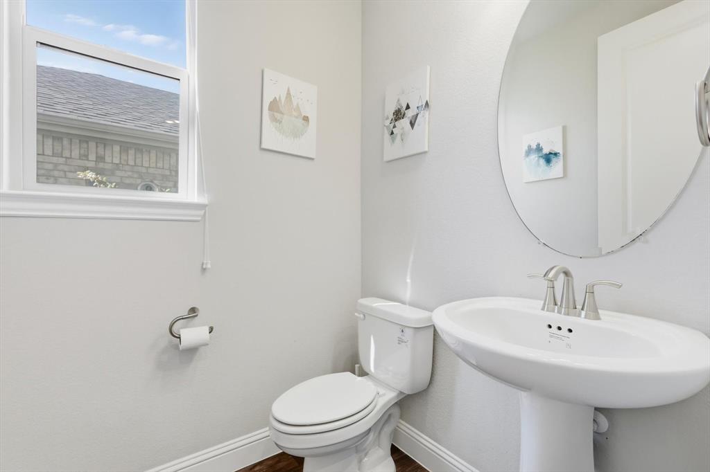 4125 Caprock Canyon Road Sachse, TX 75048 - Photo 7 of 40 a white toilet sitting next to a bathroom sink