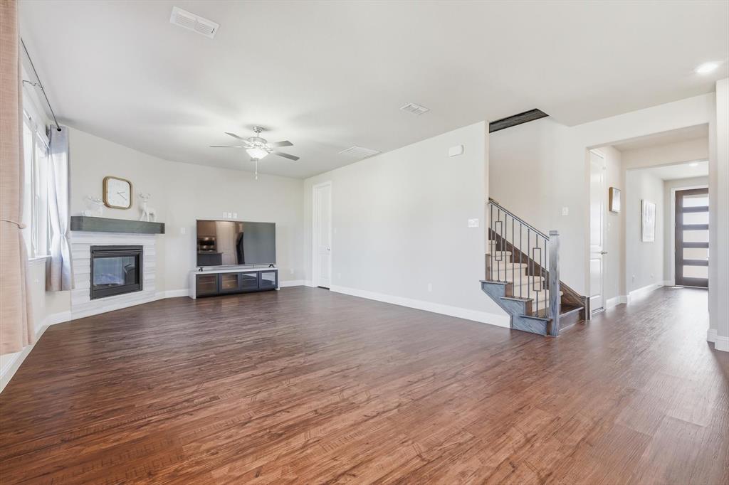 4125 Caprock Canyon Road Sachse, TX 75048 - Photo 9 of 40 a view of empty room with fireplace and wooden floor