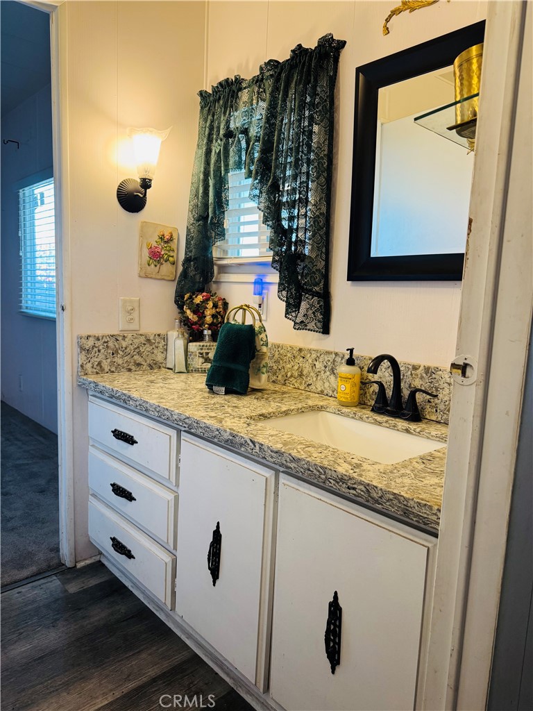 13393 Mariposa Road, Unit 281 Victorville, CA 92395 - Photo 10 of 16 a bathroom with a granite countertop sink and a mirror