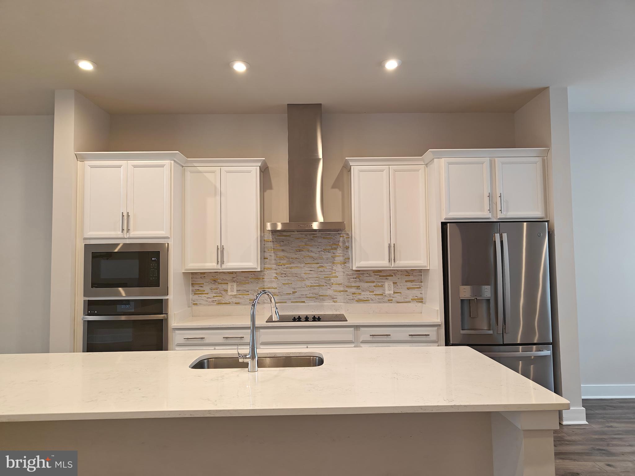 2393 Liberty Loop Herndon, VA 20171 - Photo 11 of 45 a kitchen with kitchen island granite countertop a refrigerator and a sink