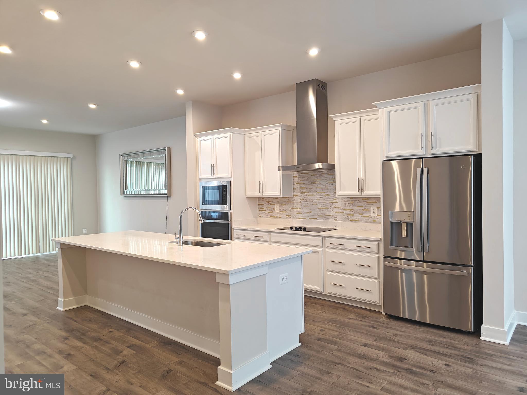 2393 Liberty Loop Herndon, VA 20171 - Photo 12 of 45 a kitchen with white cabinets and stainless steel appliances