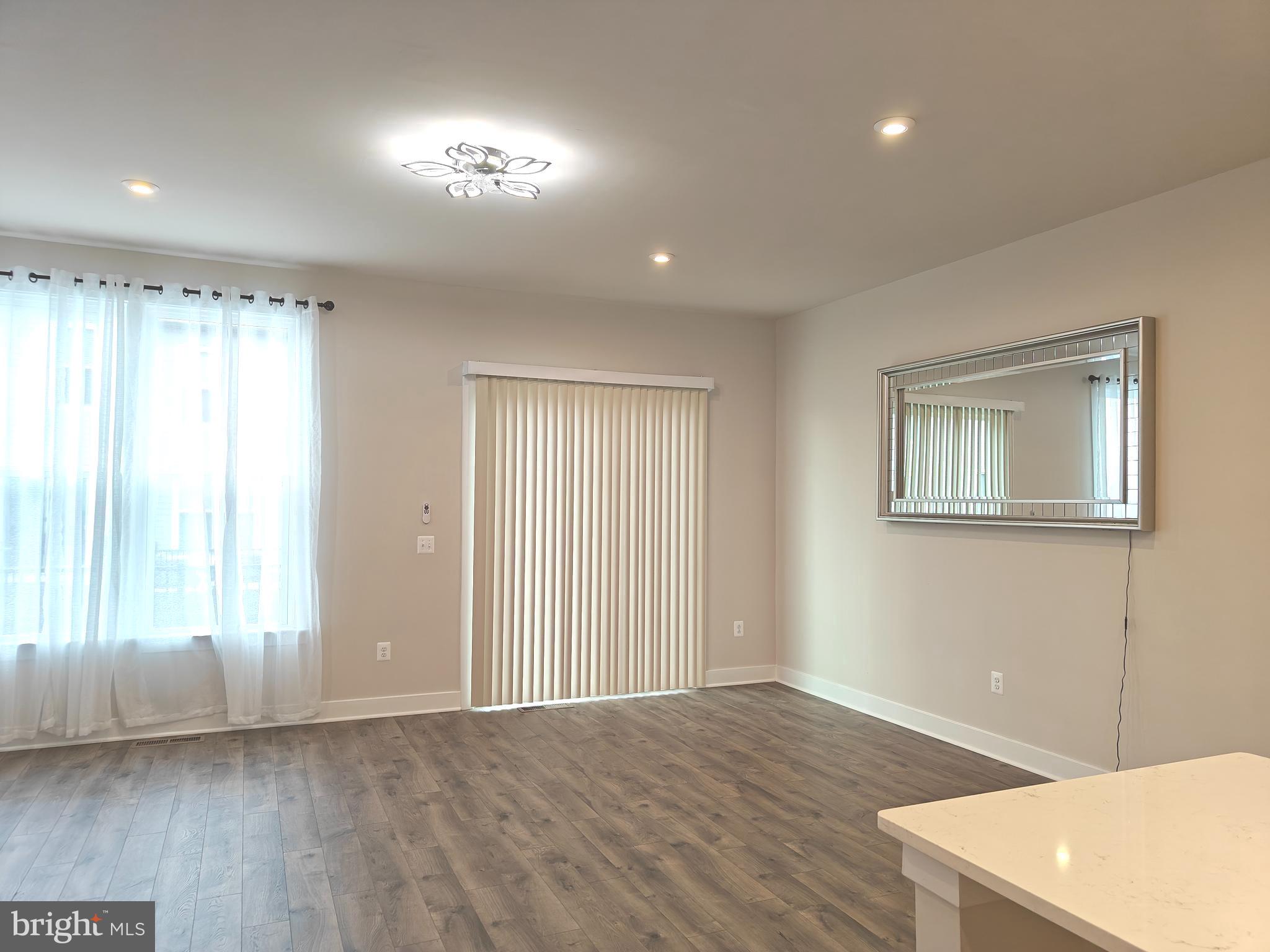 2393 Liberty Loop Herndon, VA 20171 - Photo 8 of 45 a view of an empty room with wooden floor and a window