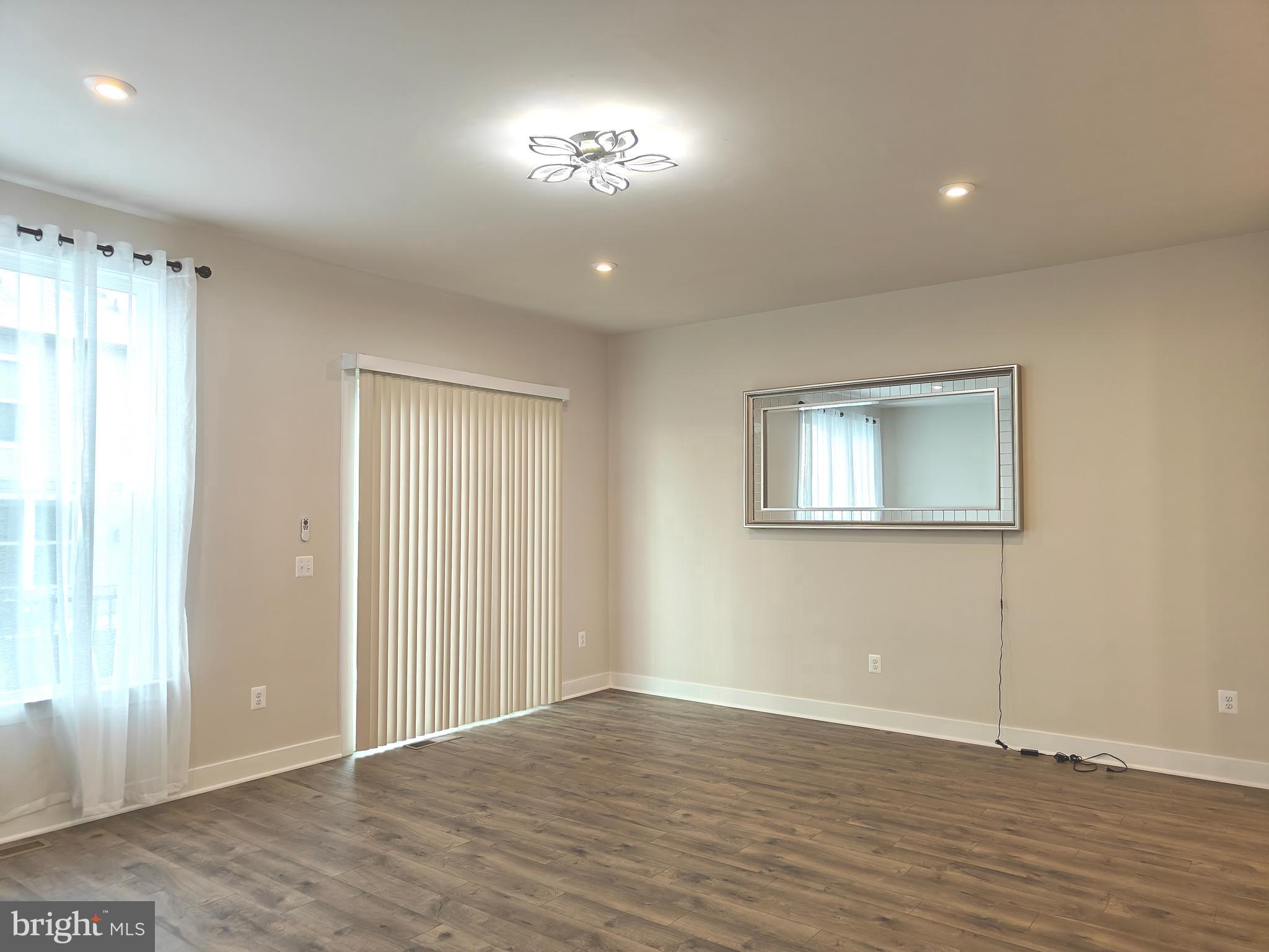 2393 Liberty Loop Herndon, VA 20171 - Photo 9 of 45 a view of an empty room with wooden floor and a window