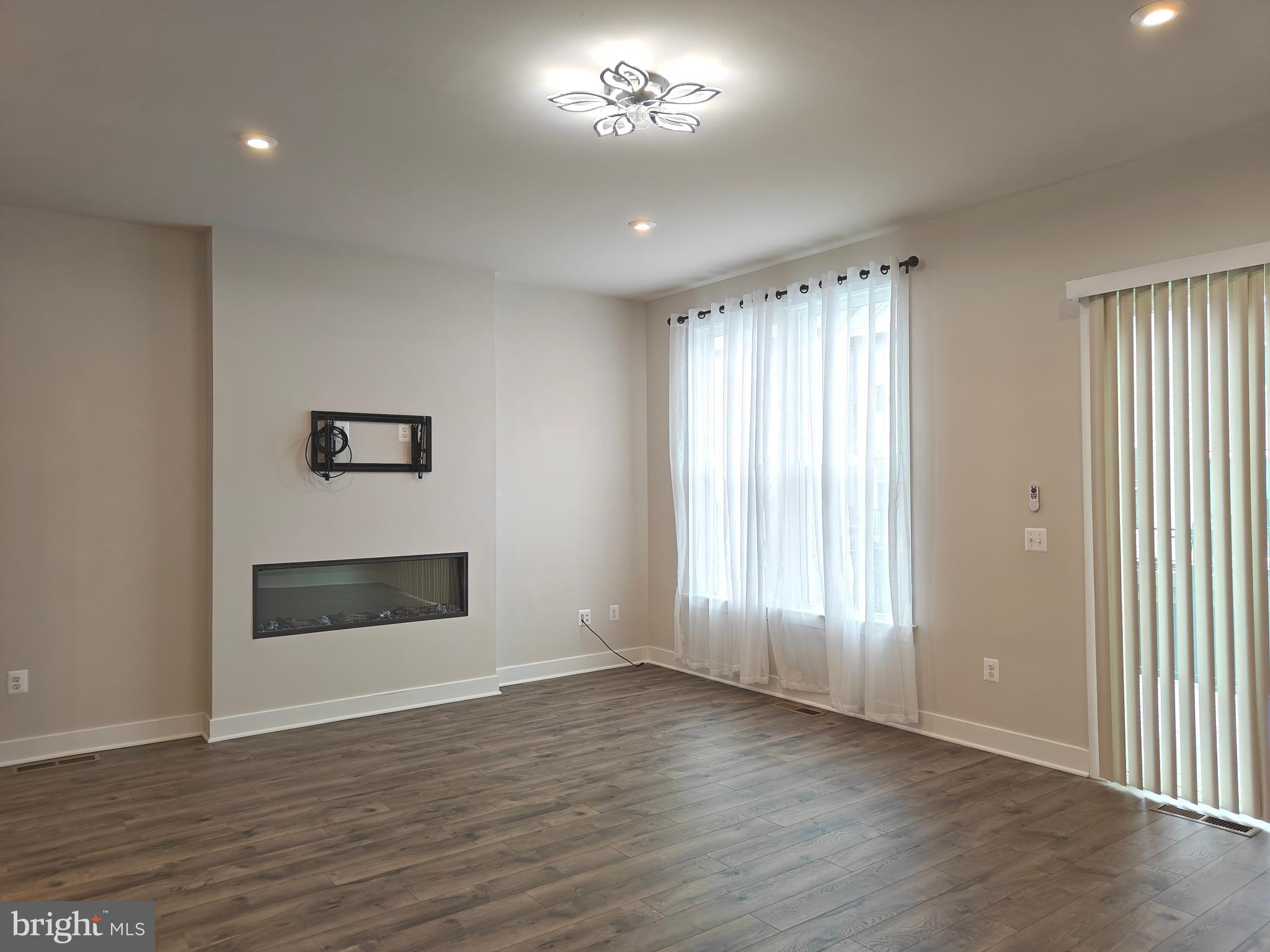 2393 Liberty Loop Herndon, VA 20171 - Photo 10 of 45 an empty room with wooden floor cabinet and windows