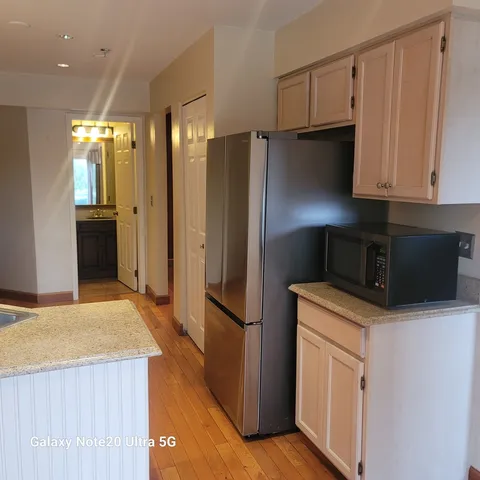 a kitchen with a refrigerator sink and cabinets