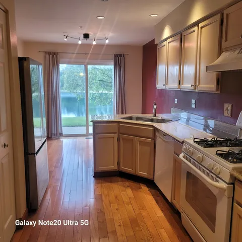 a kitchen that has a sink a stove and cabinets