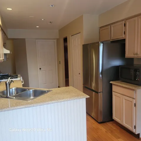 a kitchen with stainless steel appliances granite countertop a refrigerator and a sink