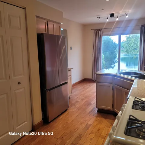 a kitchen with stainless steel appliances granite countertop a refrigerator and a stove