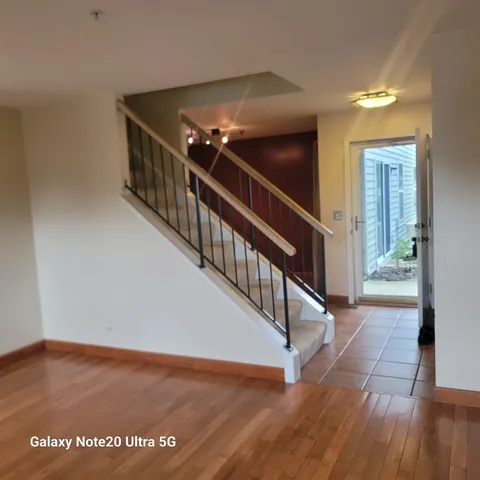 a view of a hallway with wooden floor and stairs