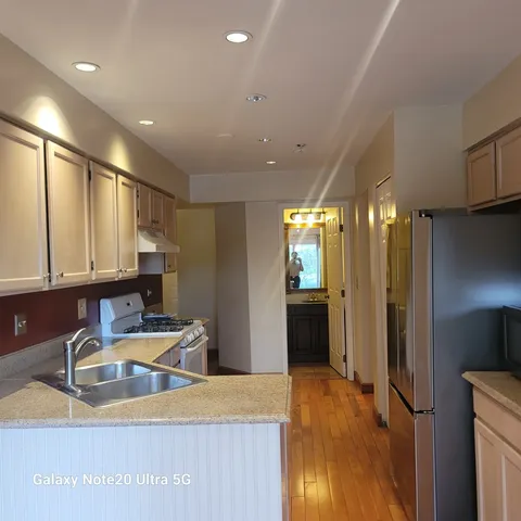 a kitchen with stainless steel appliances granite countertop a sink refrigerator and cabinets